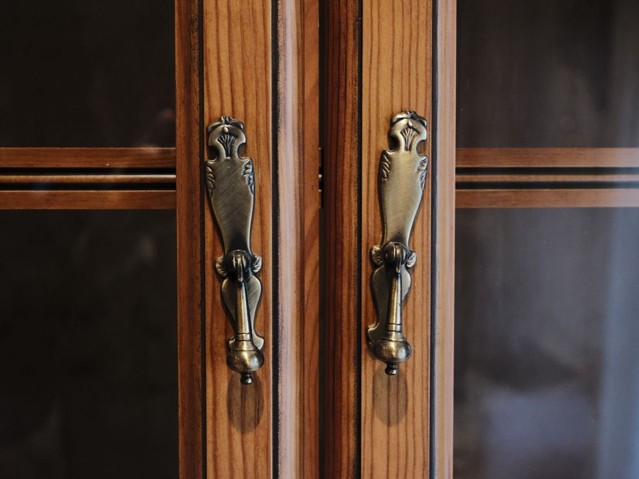 Close-up of elegant brass door handles on a wooden cabinet in Zaragoza, Spain.